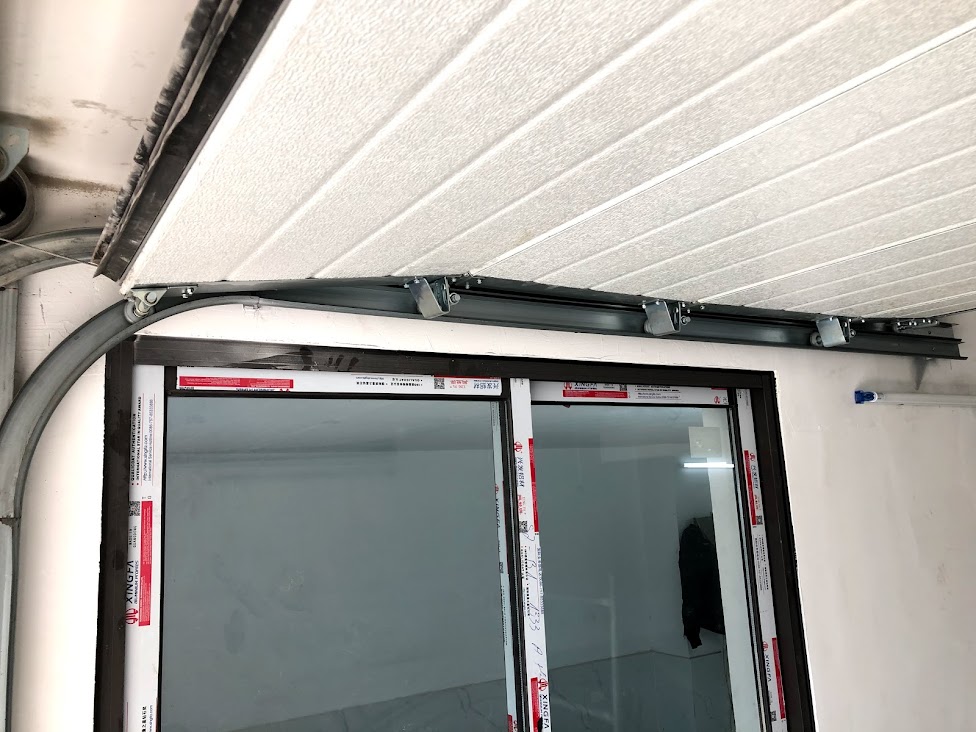 Ray trượt cửa cuốn trần lắp phía trên khung cửa kính nhôm Xingfa trong nhà đang thi công